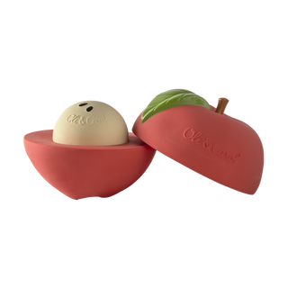 Jouet empilable en forme de pomme Oli & Carol ouvert pour montrer le hochet crème situé dans la moitié inférieure rouge, jouet pour bébé en caoutchouc naturel peint à la main.