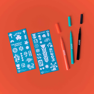 Flower temporary tattoo kit contents showing 3 open pens in black, green and orange with 2 sheets of 35 floral templates, OMY skin-safe brush tip body art for children