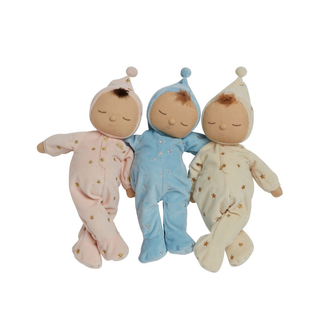 Collection « Lullaby Dozy Dinkum » d'Olli Ella : les trois poupées endormies aux yeux fermés, vêtues de grenouillères rose, bleu ciel et crème au motif d'étoiles, sont des compagnons de sommeil lestés et musicaux, parfaits pour instaurer une routine apaisante avant le coucher