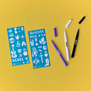 Rock temporary tattoo kit contents showing 3 open pens in black, white and purple with 2 sheets of 35 rock-themed templates, OMY skin-safe brush tip body art for children